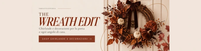 Ghirlanda decorativa autunnale con foglie bordeaux, bacche, mini zucche e fiocco in velluto per una porta d’ingresso Halloween chic.
